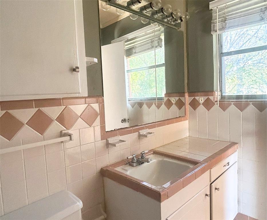 2609 Washington Street Commerce, TX 75428 - Photo 10 of 20 a bathroom with a sink and a bathtub
