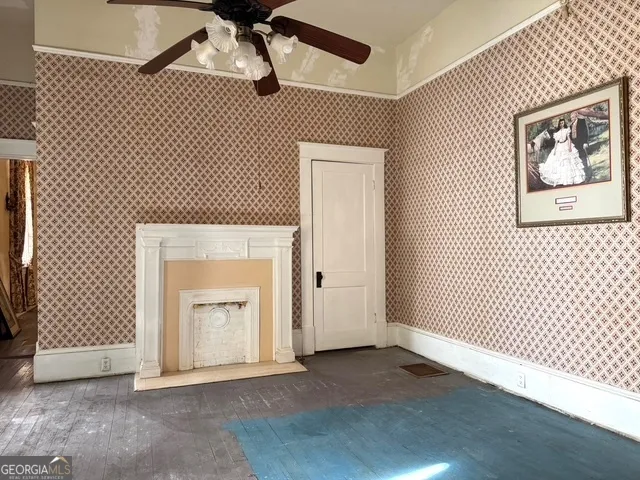 a view of a hallway with wooden floor and a dining room