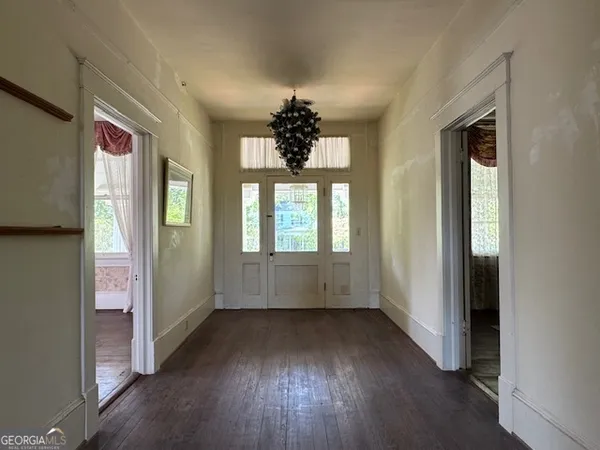 a view of an empty room with window and wooden floor