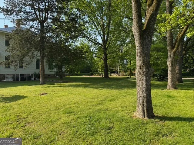 a view of a swimming pool with lawn chairs and a big yard