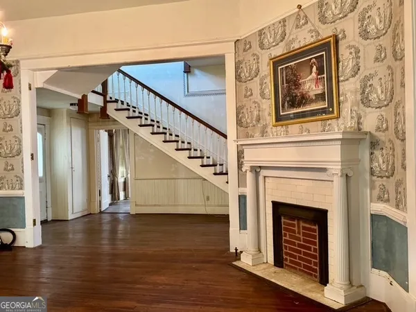 a view of a livingroom with wooden floor and a fireplace