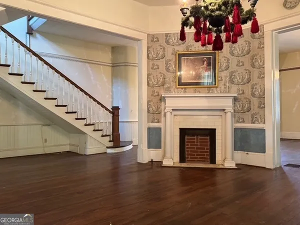 a view of a livingroom with wooden floor a fireplace and entryway