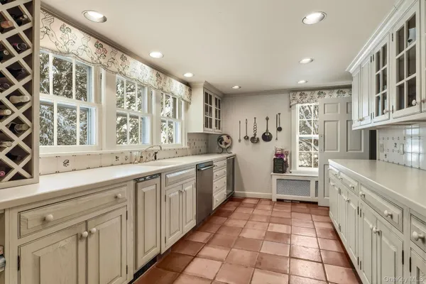a large white kitchen with a large window