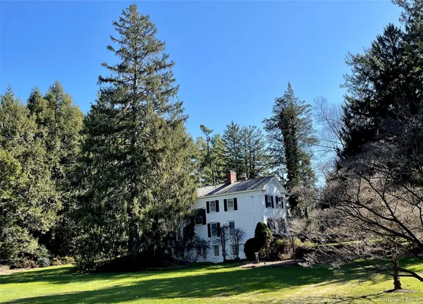 a view of a house with garden and trees in the background