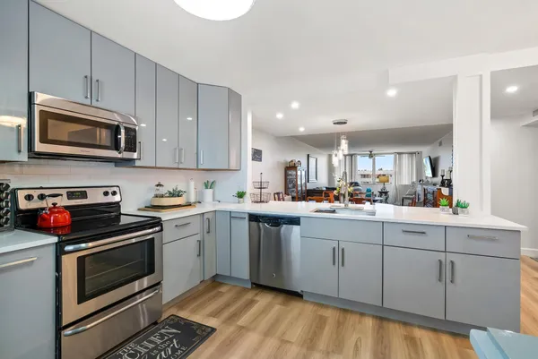 a kitchen with stainless steel appliances granite countertop a stove a sink and a microwave