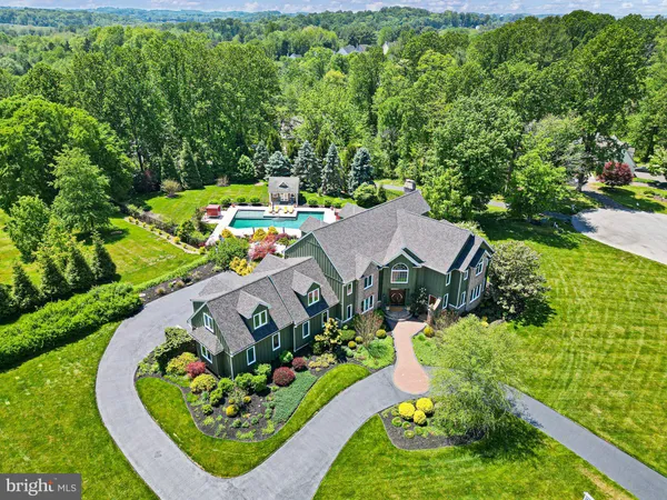 an aerial view of residential houses with outdoor space and trees
