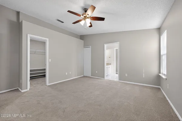 a view of an empty room with a ceiling fan
