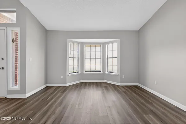 a view of wooden floor and windows in a room