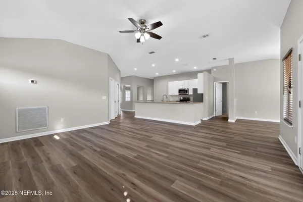 a view of a kitchen with a stove cabinets wooden floor and a kitchen view
