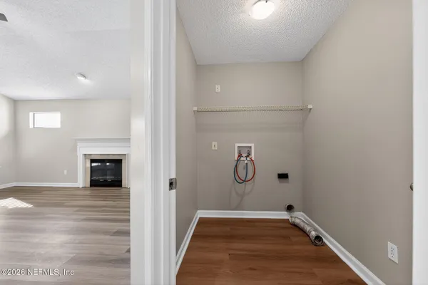 a view of a livingroom with wooden floor and a fireplace
