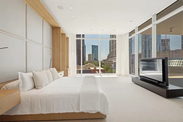 a spacious bedroom with a bed and glass door