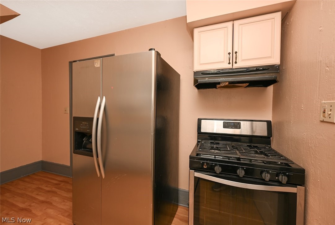 77 West Mildred Avenue Akron, OH 44310 - Photo 16 of 40 Kitchen with stainless steel appliances, light wood-style flooring, and white cabinets