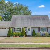 a front view of a house with plants and garage