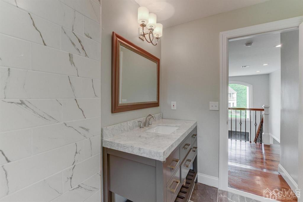 7 Ramsey Road Edison, NJ 08820 - Photo 21 of 28 a bathroom with a granite countertop sink and a mirror