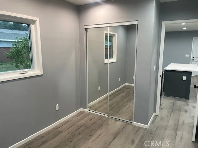 an empty room with wooden floor and a bathroom