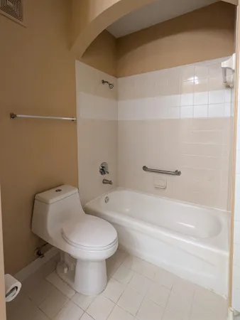 a white toilet sitting next to a bath tub