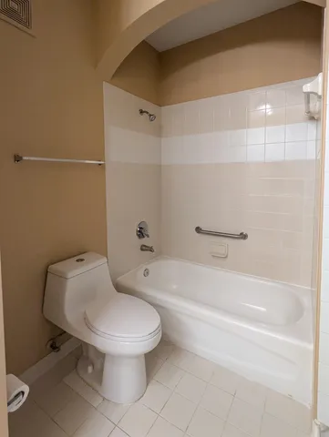 a white toilet sitting next to a bath tub