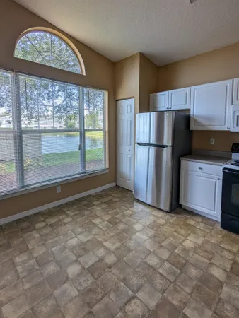 a view of a kitchen with a stove fridge and wooden floor