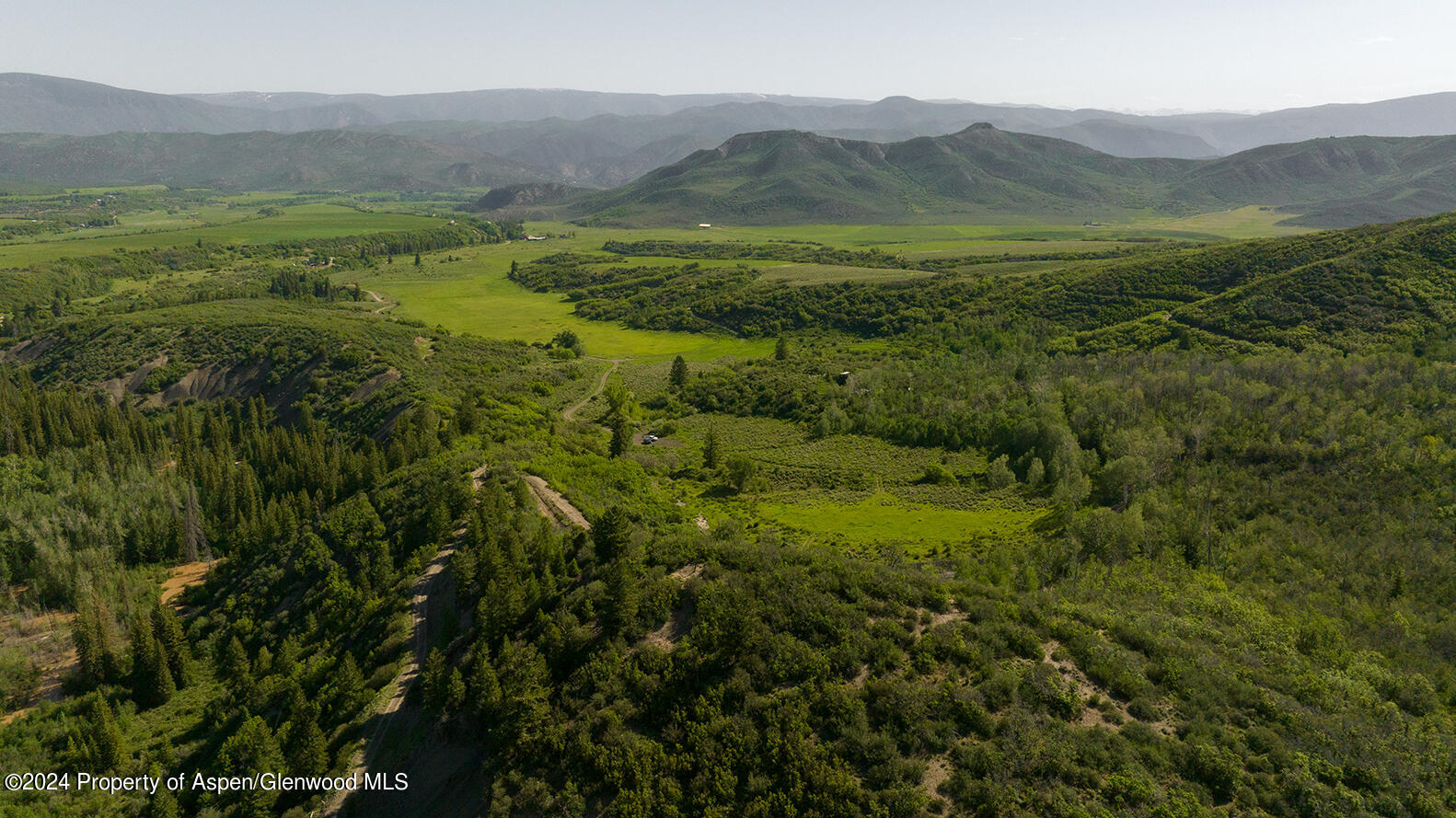 1012 Monastery Road Snowmass, CO 81654 - Photo 6 of 96 a view of a lush green hillside and houses