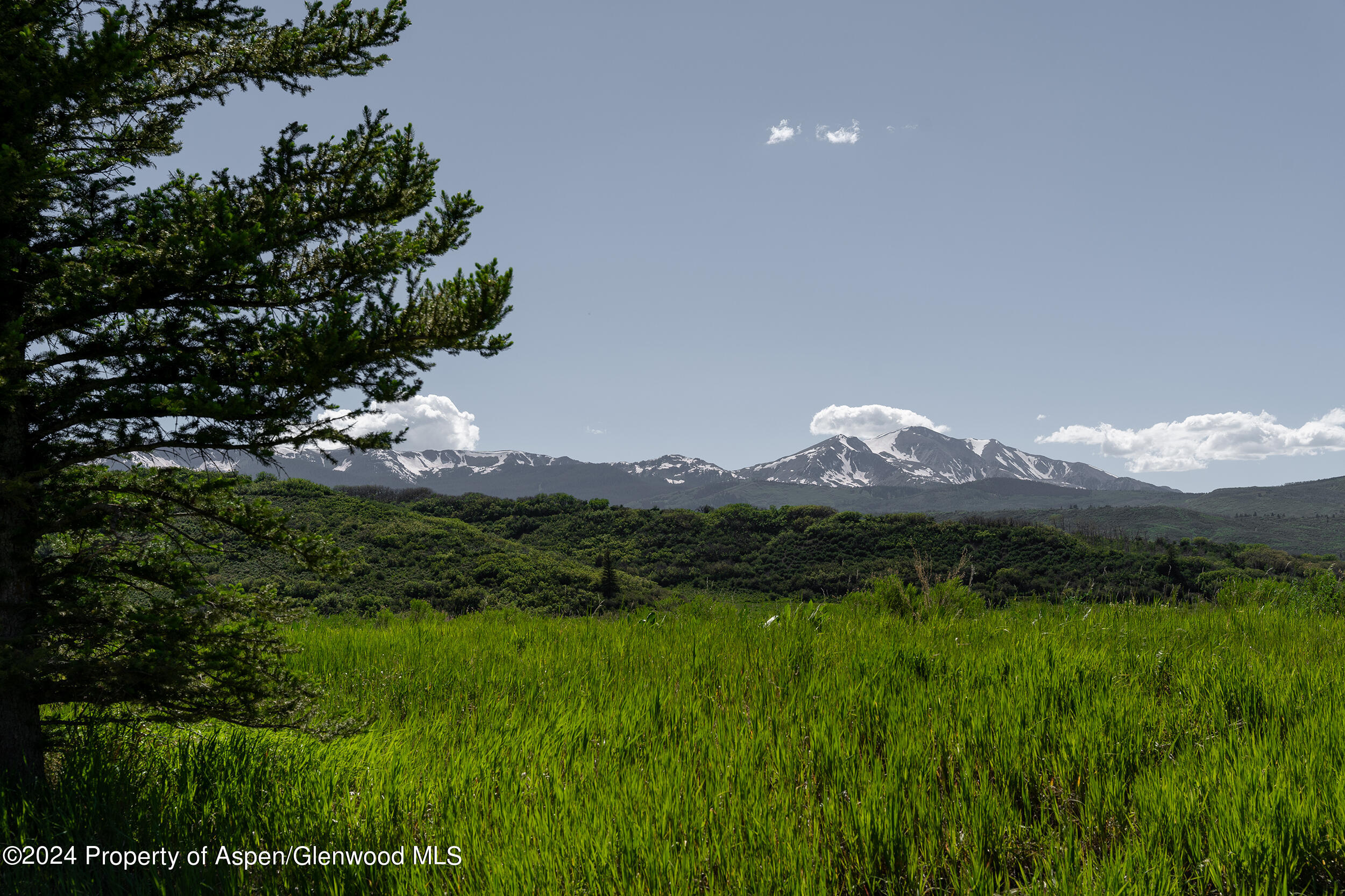 1012 Monastery Road Snowmass, CO 81654 - Photo 80 of 96 a view of a lush green hillside and a building in the background
