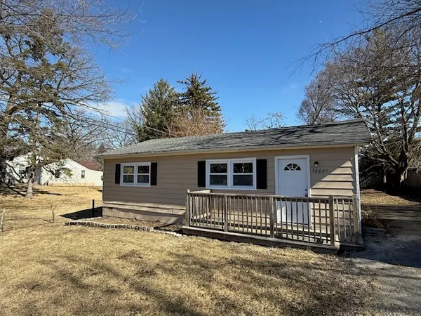 a view of a house with a yard and wooden fence