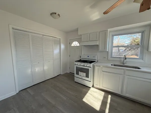 a kitchen with granite countertop a stove a sink and a refrigerator