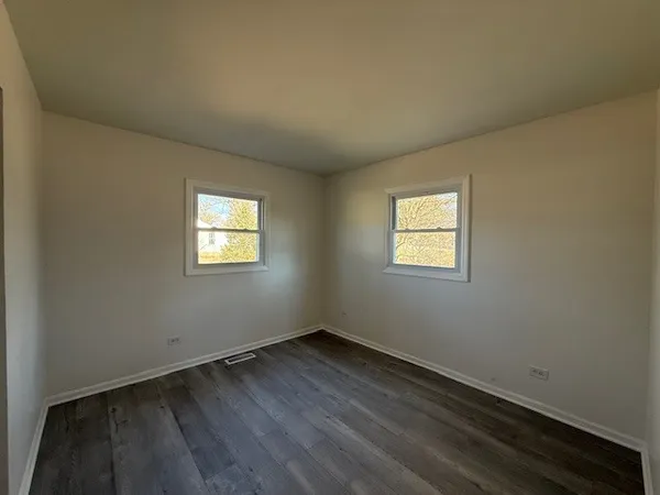 a view of a room that has wooden floor and white walls