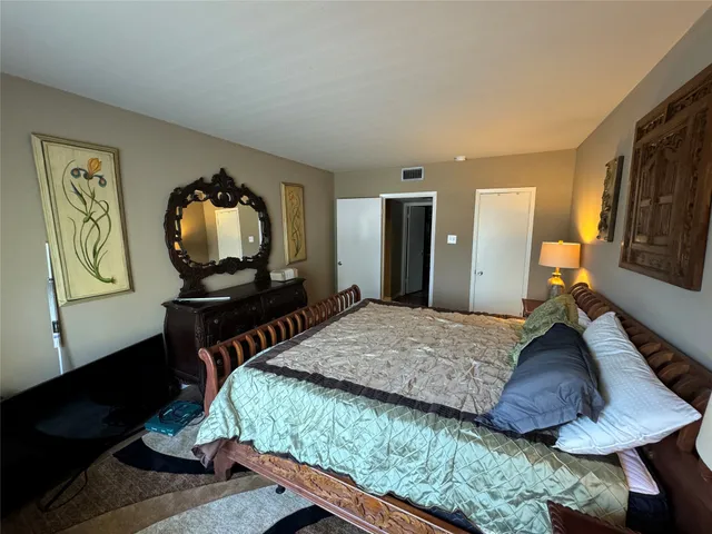 a bedroom with a bed window and dresser