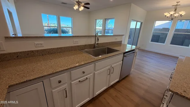 a kitchen with granite countertop a sink a window stainless steel appliances and cabinets