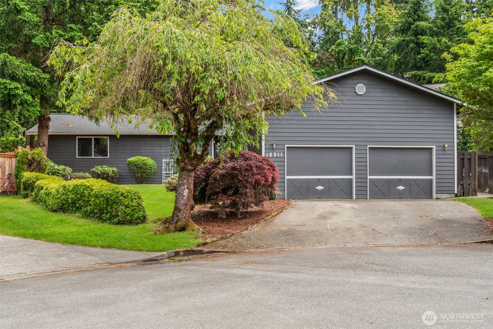 a front view of a house with a garden and garage