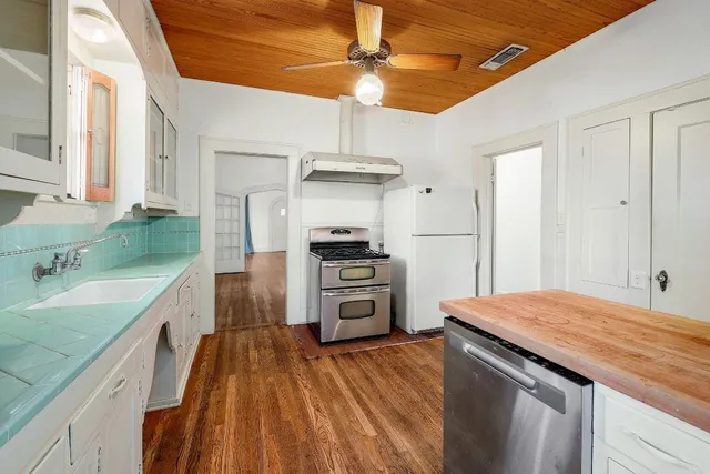 a kitchen with a sink a stove and cabinets