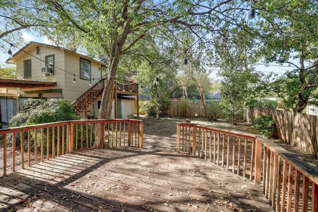 a view of a wooden deck and a yard with wooden fence