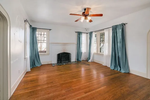 a view of an empty room with window and fireplace
