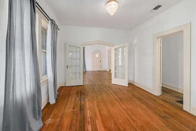 a view of a room with wooden floor and entryway