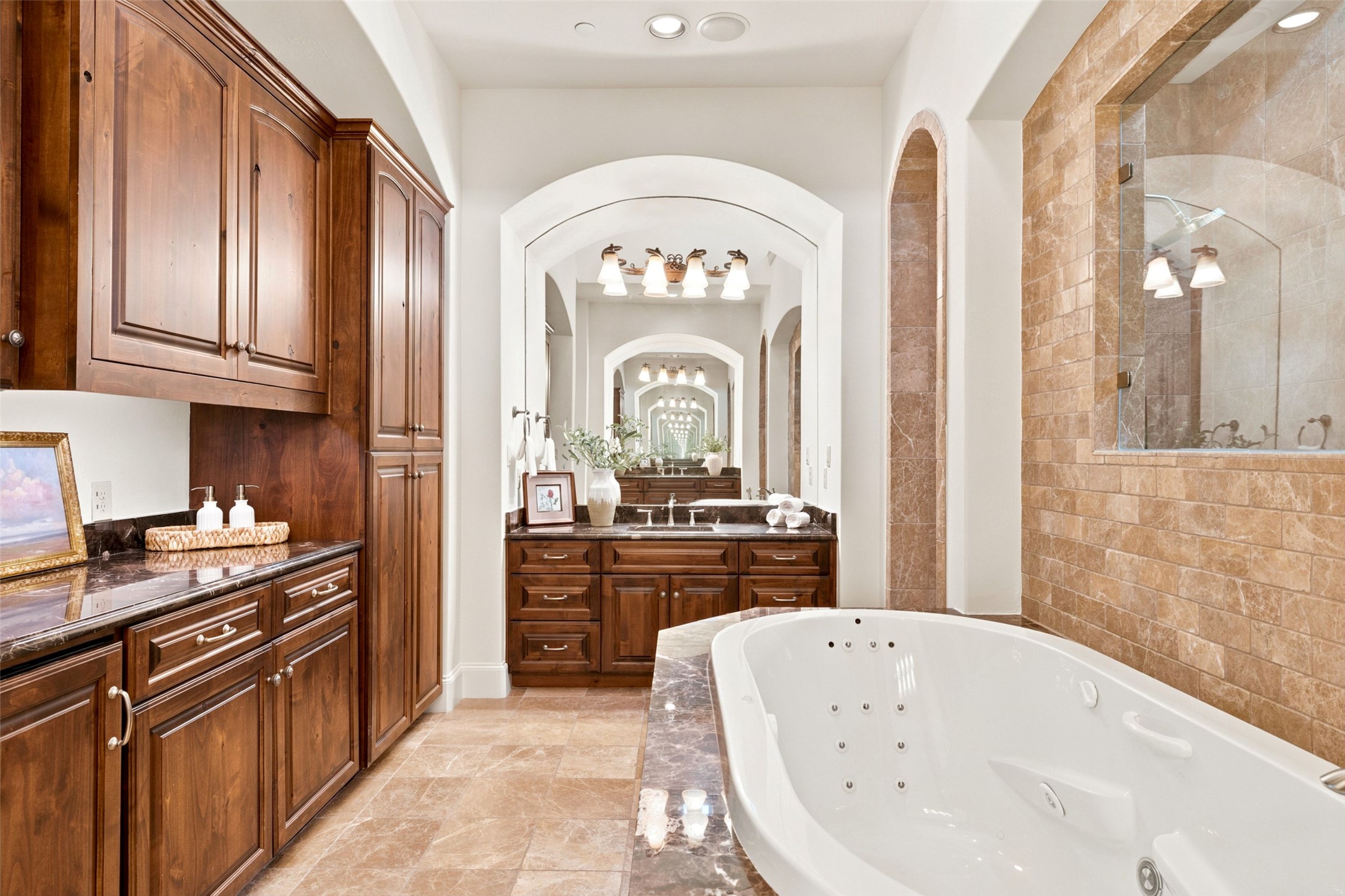 1414 The High Road Austin, TX 78746 - Photo 19 of 40 Elegant primary bathroom offers a large soaking tub and rich wooden cabinetry.