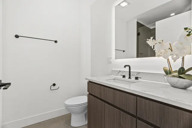 a bathroom with a granite countertop sink a toilet and a mirror