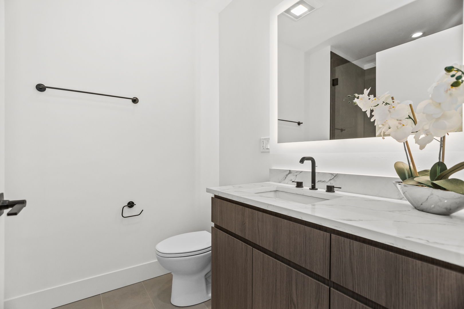 153 West Ohio Street, Unit 504 Chicago, IL 60654 - Photo 7 of 13 a bathroom with a granite countertop sink a toilet and a mirror
