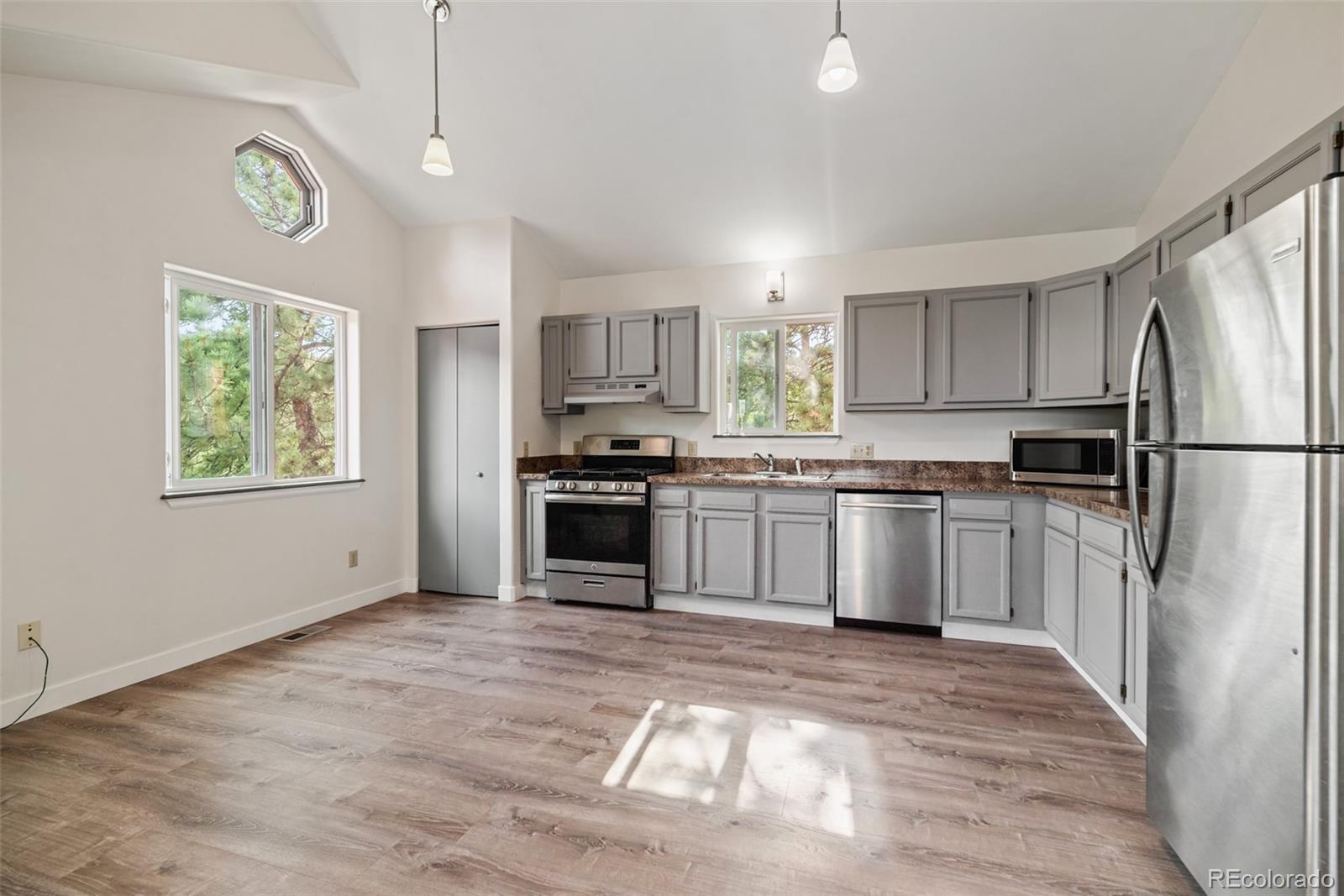 241 Schooley Road Bailey, CO 80421 - Photo 16 of 35 a kitchen with white cabinets and stainless steel appliances