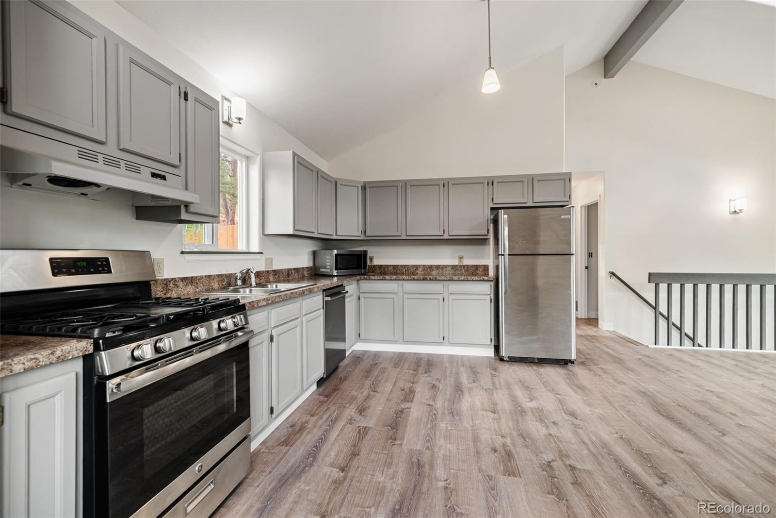 241 Schooley Road Bailey, CO 80421 - Photo 17 of 35 a kitchen with granite countertop a stove top oven and cabinets