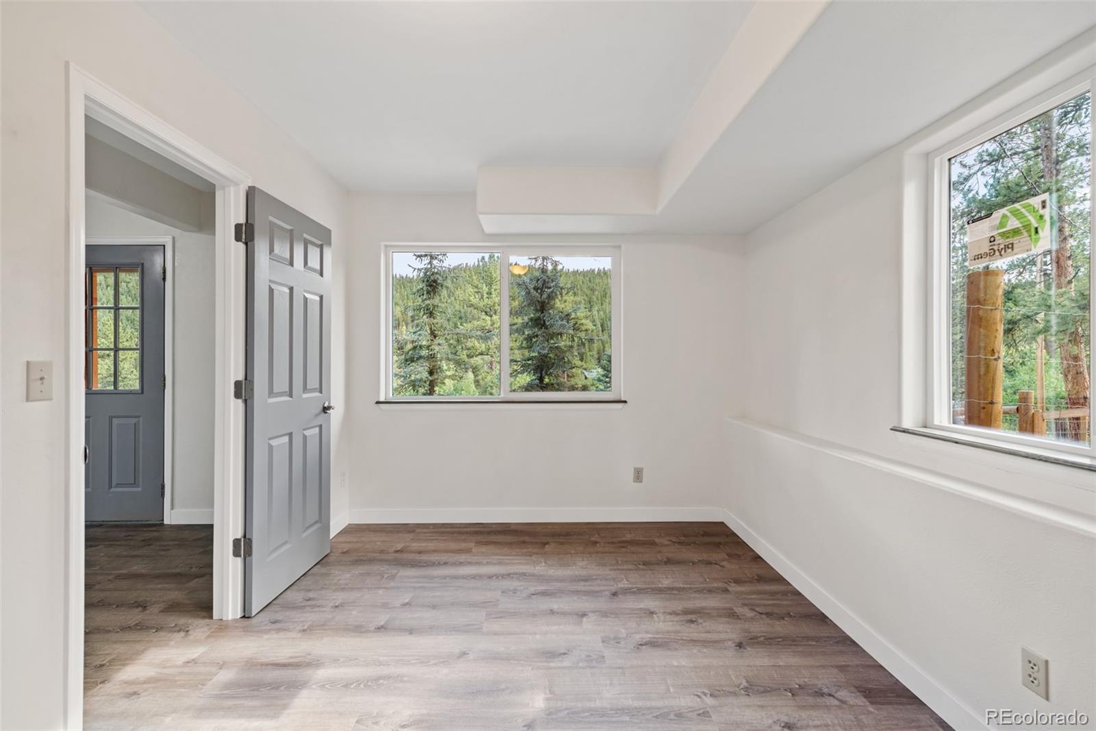 241 Schooley Road Bailey, CO 80421 - Photo 23 of 35 an empty room with wooden floor and windows