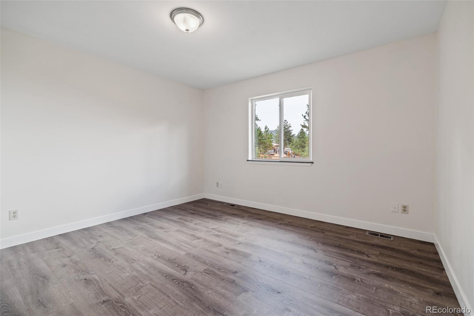 241 Schooley Road Bailey, CO 80421 - Photo 25 of 35 an empty room with wooden floor and windows