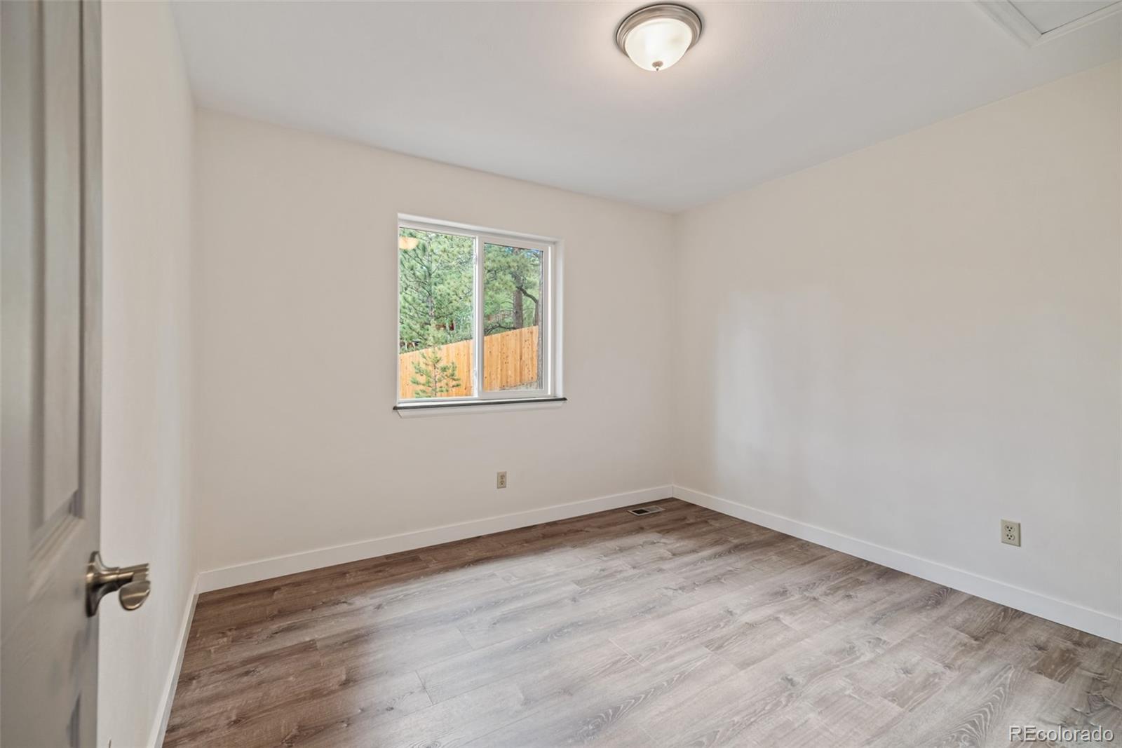 241 Schooley Road Bailey, CO 80421 - Photo 26 of 35 an empty room with wooden floor and windows