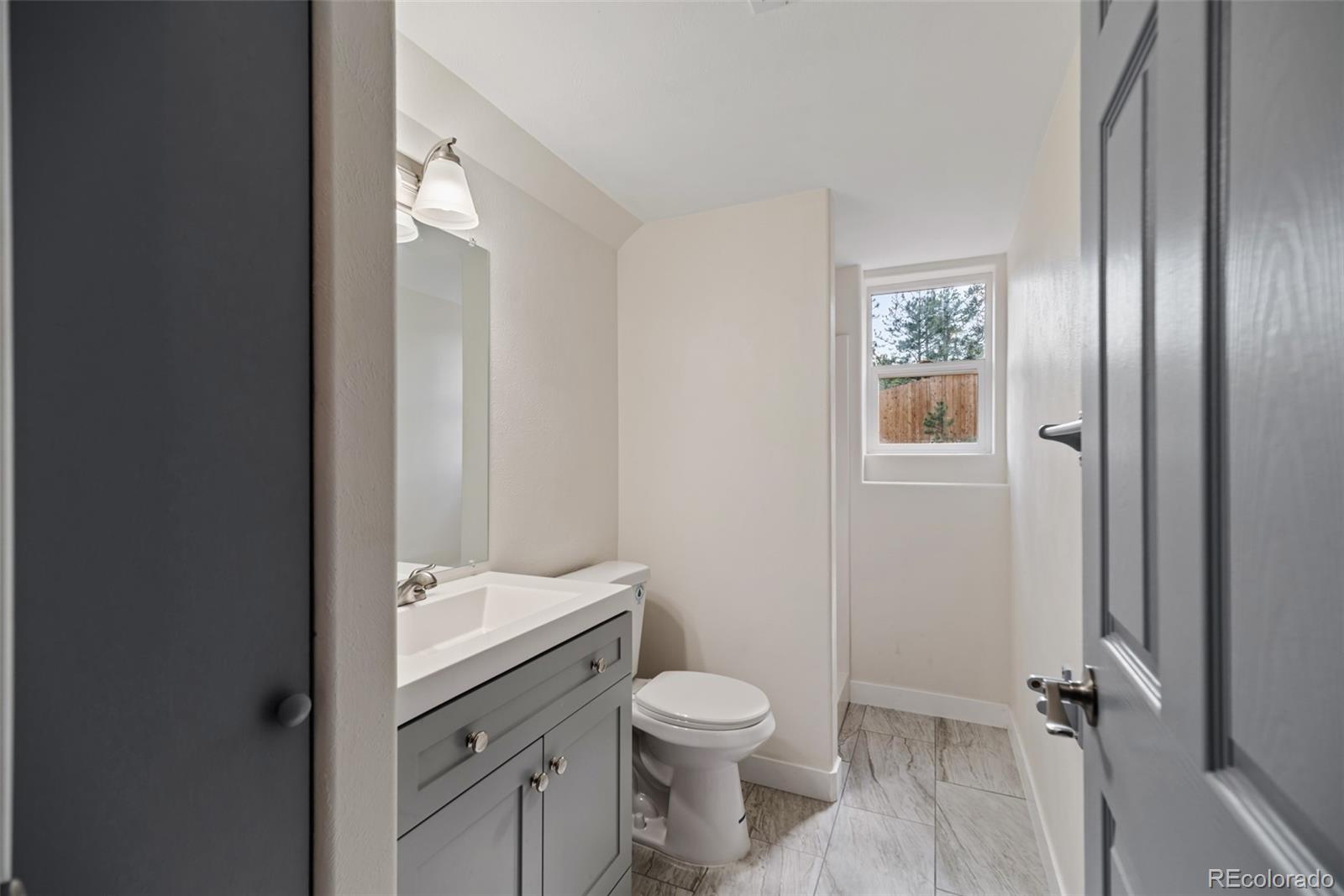 241 Schooley Road Bailey, CO 80421 - Photo 27 of 35 a bathroom with a toilet a sink and mirror