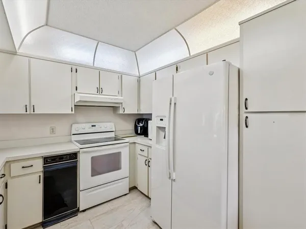 a dinning room with stainless steel appliances kitchen island granite countertop a refrigerator and a sink