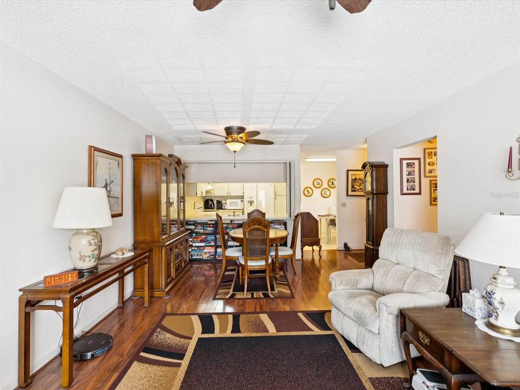 12141 Spartan Way, Unit 202 Hudson, FL 34667 - Photo 19 of 45 a living room with furniture a chandelier and a dining table