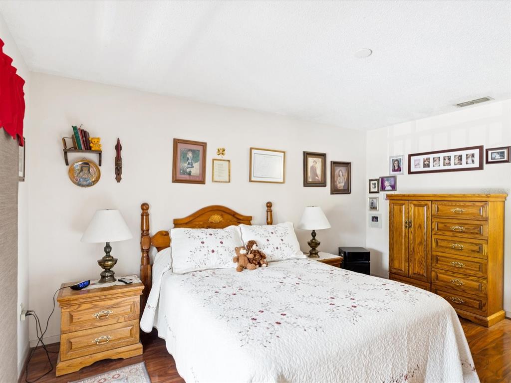 12141 Spartan Way, Unit 202 Hudson, FL 34667 - Photo 20 of 45 a bedroom with a bed and wooden floor