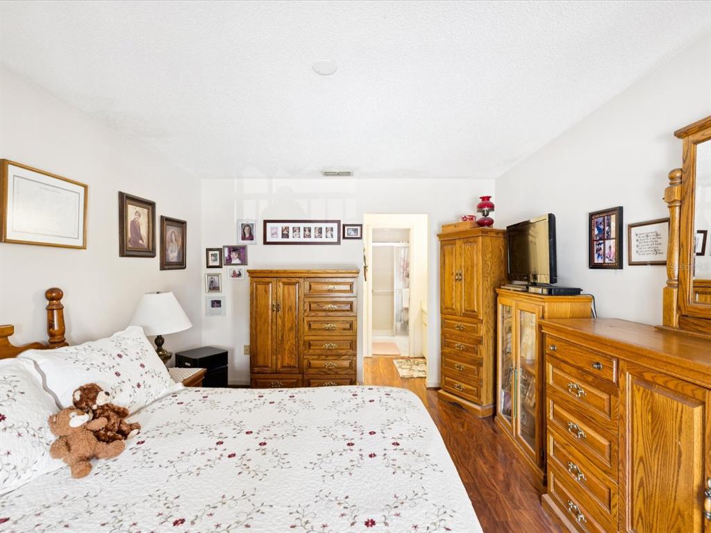 12141 Spartan Way, Unit 202 Hudson, FL 34667 - Photo 21 of 45 a bedroom with a bed and wooden floor