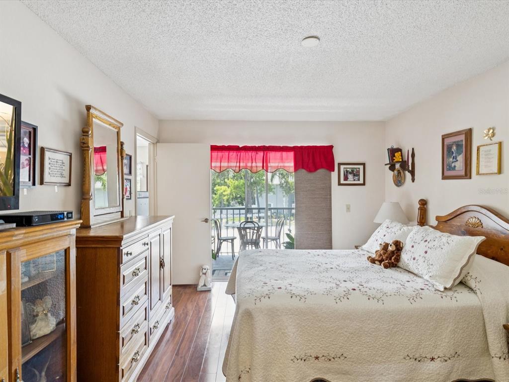 12141 Spartan Way, Unit 202 Hudson, FL 34667 - Photo 22 of 45 a bedroom with a bed dresser and a large window