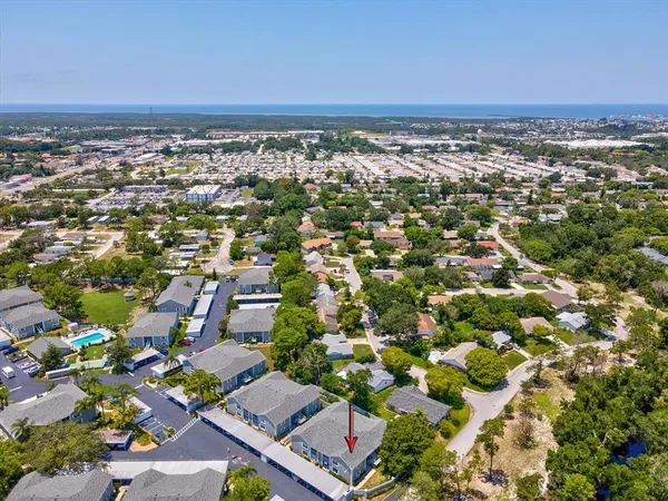an aerial view of residential houses with outdoor space and trees