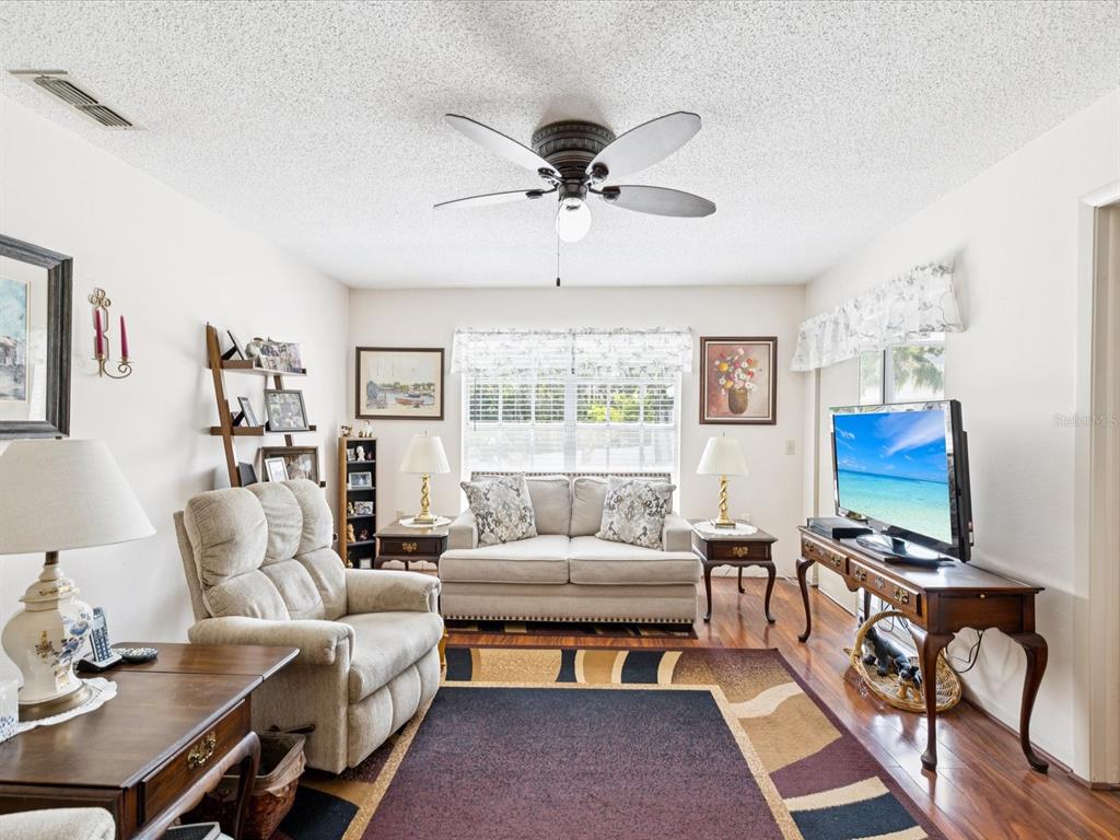12141 Spartan Way, Unit 202 Hudson, FL 34667 - Photo 5 of 45 a living room with furniture a chandelier and a window